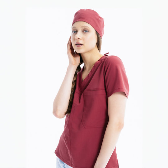 Maroon scrub top with V-neck, chest pocket and matching scrub cap
