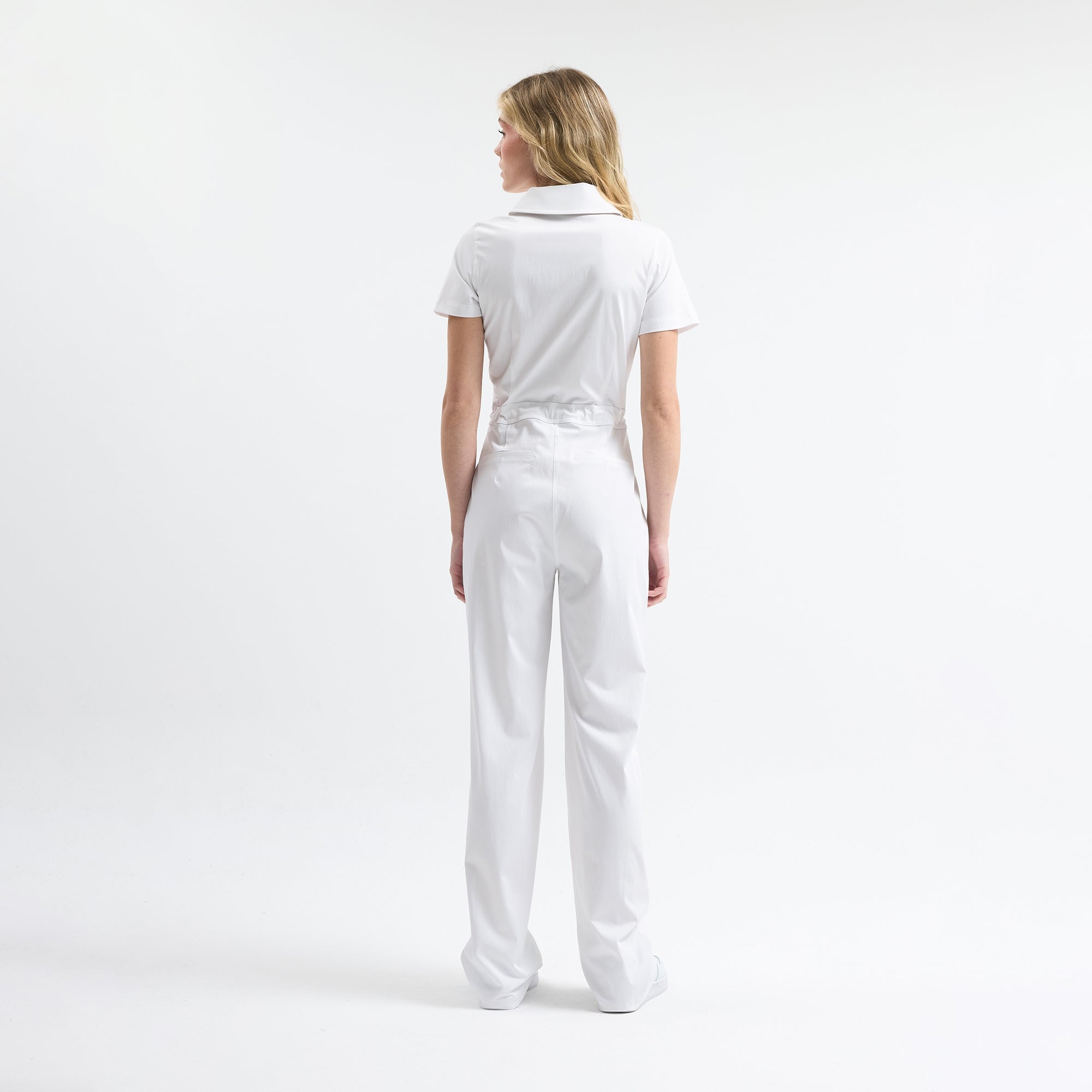 White scrub tulum back view, short sleeves, drawstring waist, full-length legs.