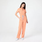 Tangerine scrub tulum with short sleeves, front zipper, and patch pockets