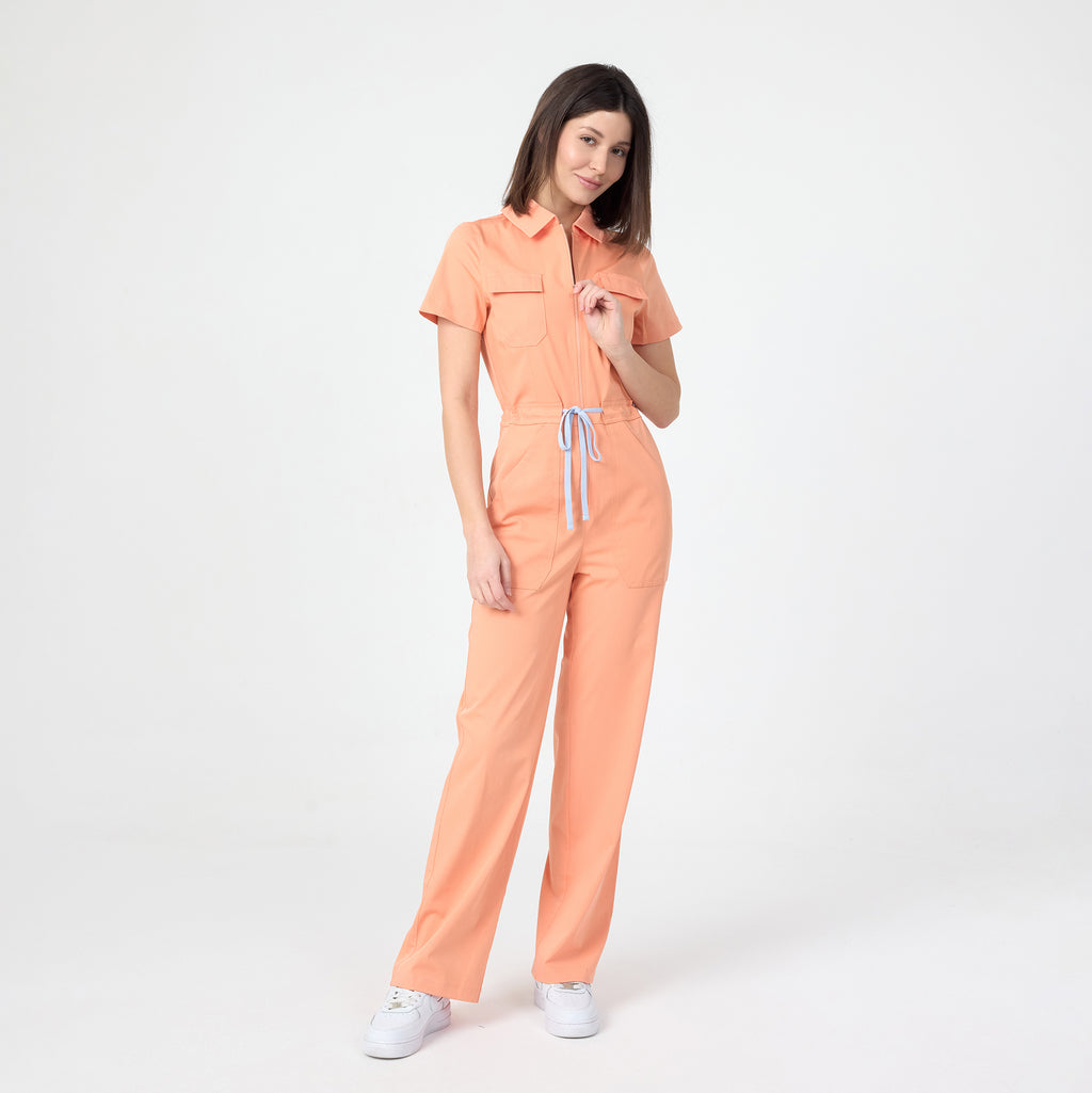 Tangerine scrub tulum with short sleeves, drawstring waist, and wide legs