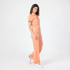 Tangerine scrub tulum with short sleeves, front zipper, and straight wide legs