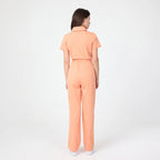 Tangerine scrub tulum back view with short sleeves and waist seam