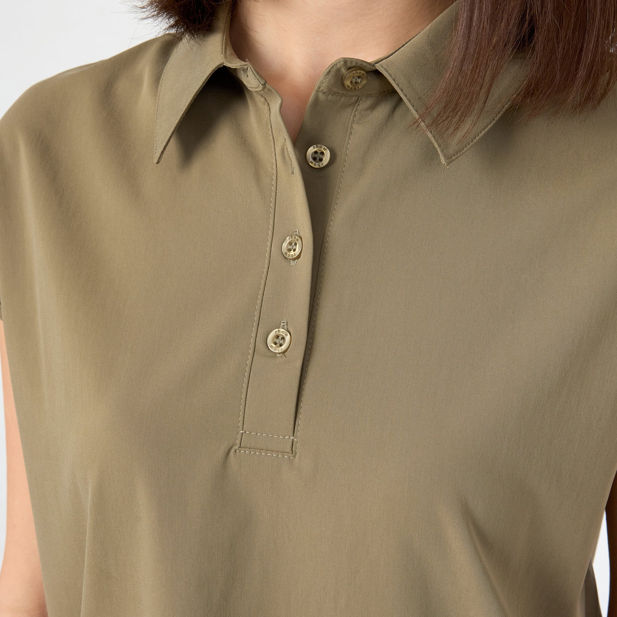 Close-up of olive polo neckline and button placket