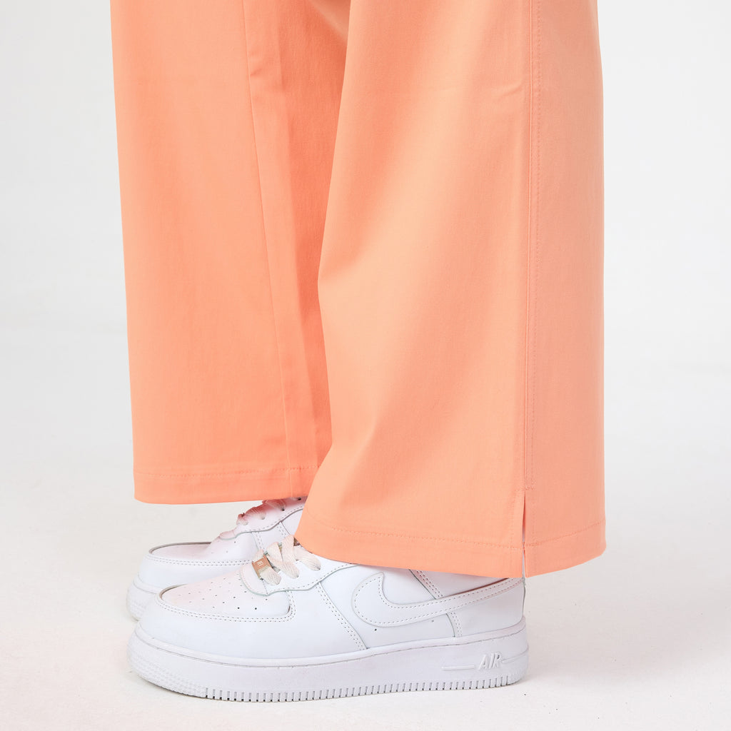 Tangerine scrub pant leg with side seam and wide hem
