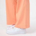 Tangerine scrub pant leg with side seam and wide hem