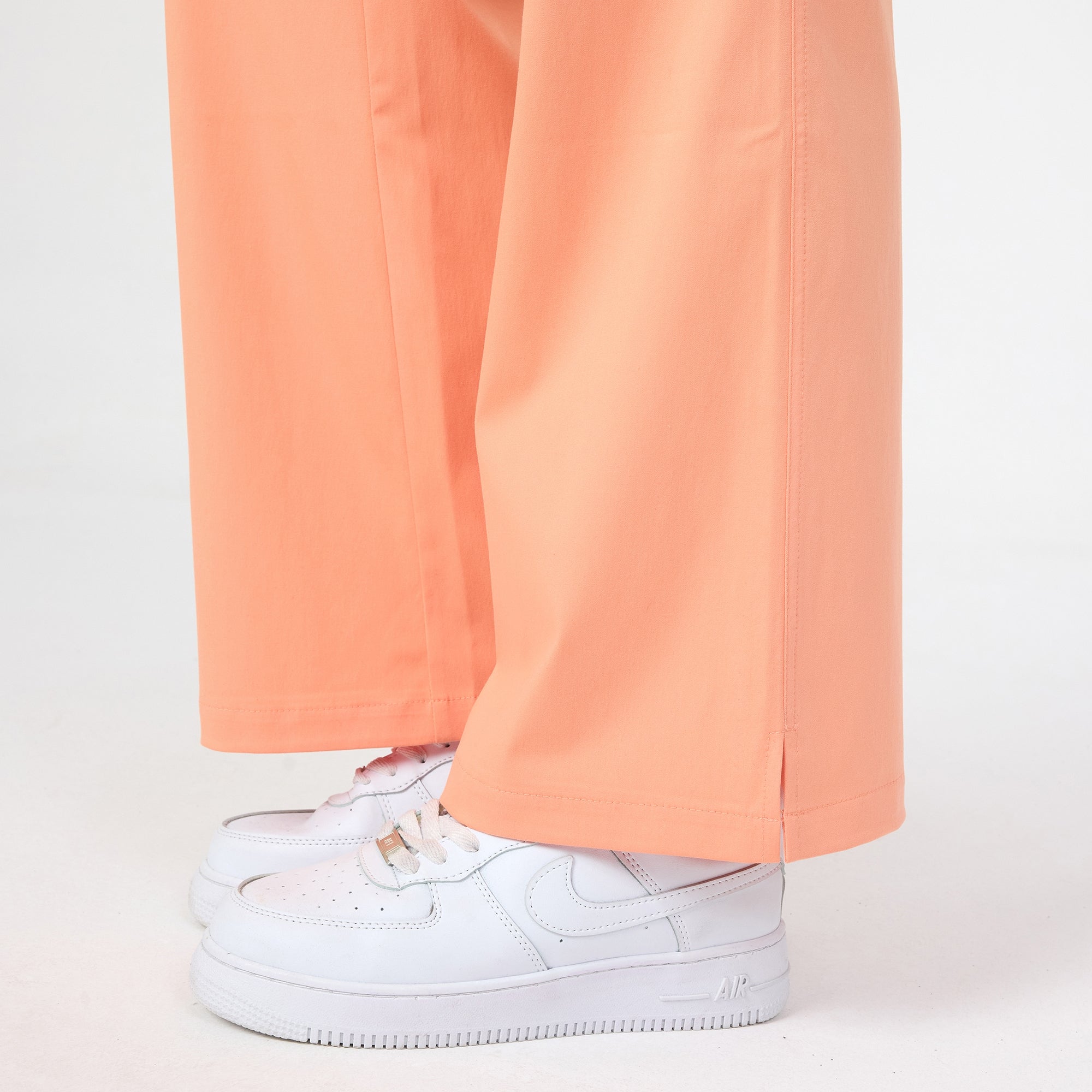 Tangerine scrub pant leg with side seam and wide hem