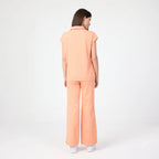 Tangerine scrub pants back view with elastic waistband and straight legs
