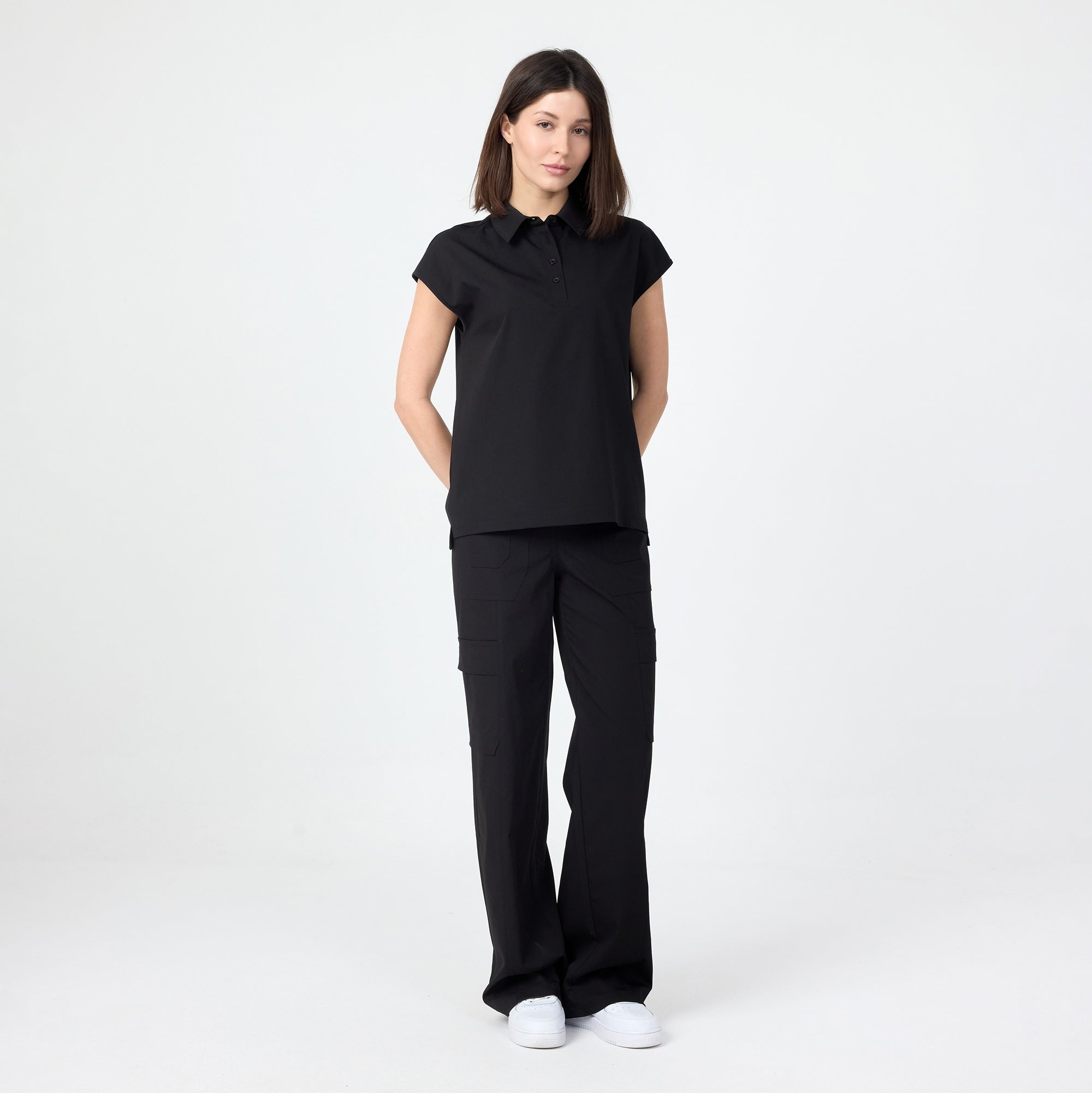 Black polo T-shirt on model, short sleeves and collared button front