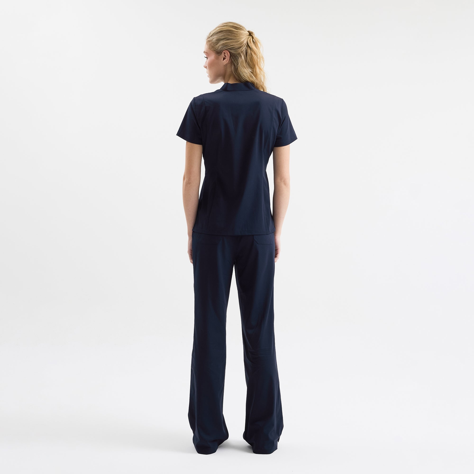 Sırt görünümü navy scrub pantolon; bel lastiği ve düz kesim.