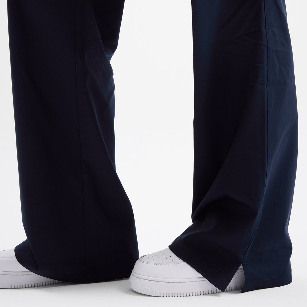 Navy scrub pantolon paça altı; geniş form ve dikiş detayları.