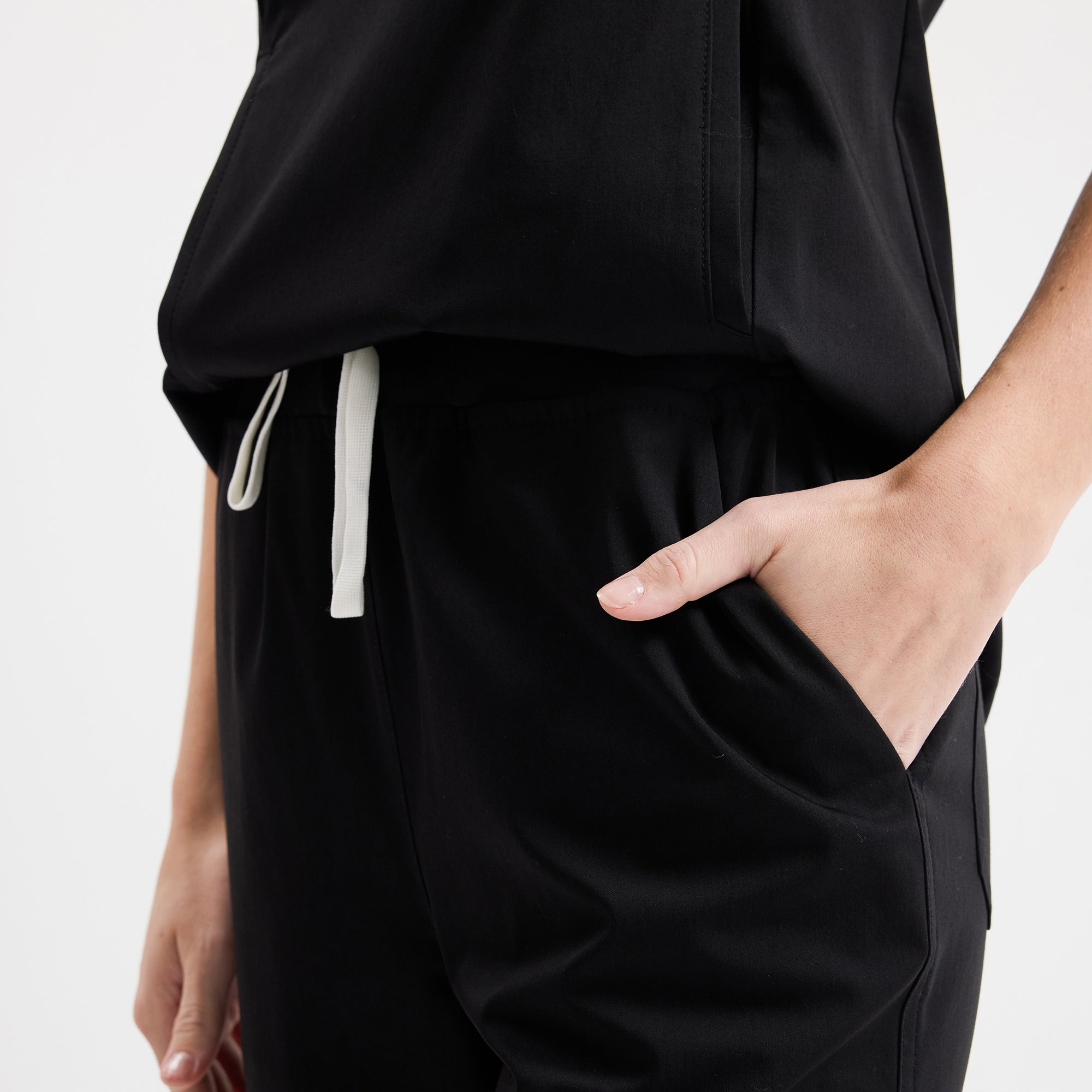 Siyah scrub pantolon; yan cep ve beli ayarlanabilir bağcık detayı
