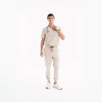 Açık bej scrub jogger pantolon; bağcık kemerli bel ve lastikli alt paça.
