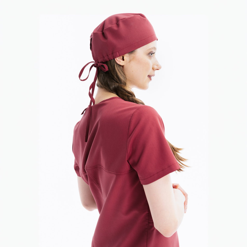 Maroon scrub top and cap, side view with back ties at hood