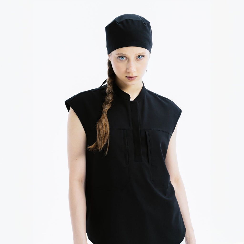 Black sleeveless scrub top with stand collar and matching scrub cap, front view