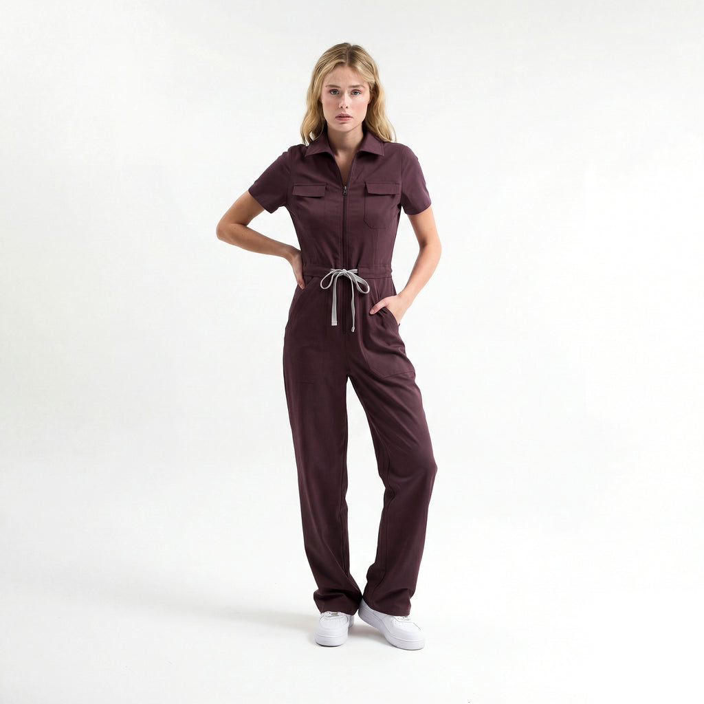 Bordo scrub tulum; kısa kollu, önden fermuarlı, belden bağcıklı pantolon paçası geniş